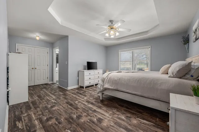 a spacious bedroom with a bed and a chandelier