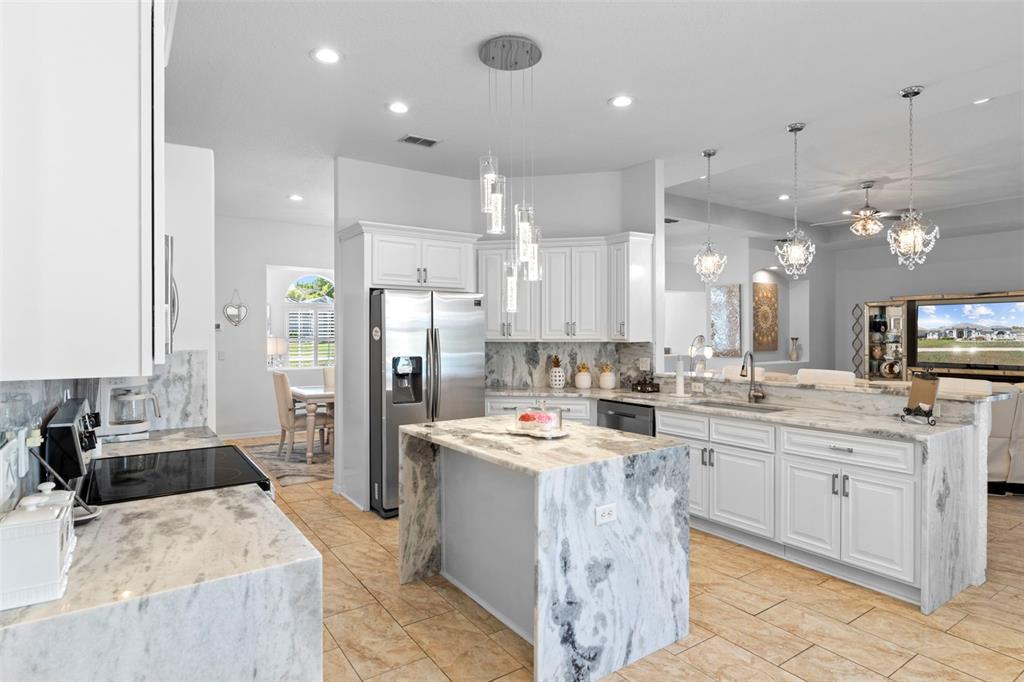 4061 Misty View Drive Spring Hill, FL 34609 - Photo 27 of 70 a large kitchen with stainless steel appliances kitchen island granite countertop a large counter top a stove a sink a refrigerator and cabinets