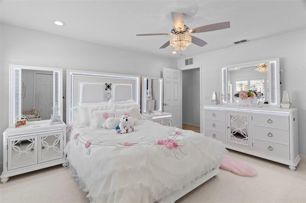 4061 Misty View Drive Spring Hill, FL 34609 - Photo 46 of 70 a bedroom with a bed a chandelier and a dresser