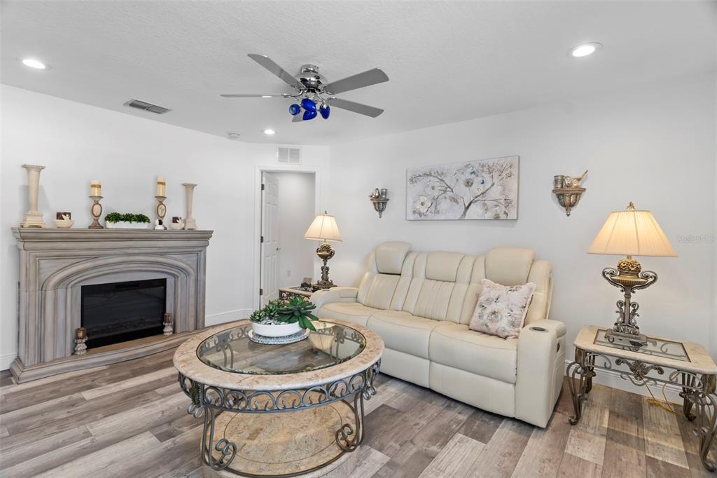 4061 Misty View Drive Spring Hill, FL 34609 - Photo 50 of 70 a living room with furniture a chandelier and a fireplace