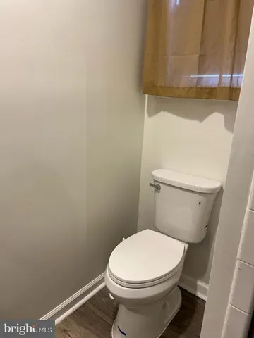 a white toilet sitting next to a shower