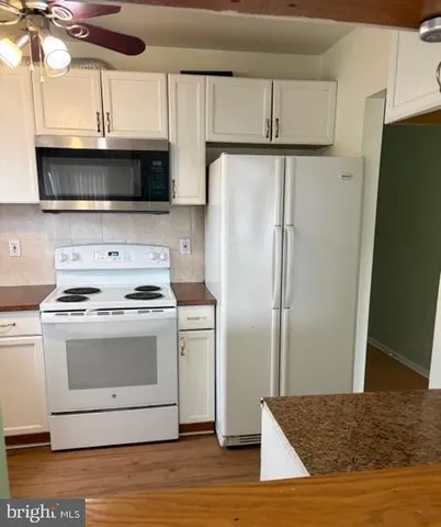 a kitchen with stainless steel appliances granite countertop a refrigerator stove and microwave