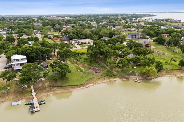 an aerial view of a houses with a yard and lake view