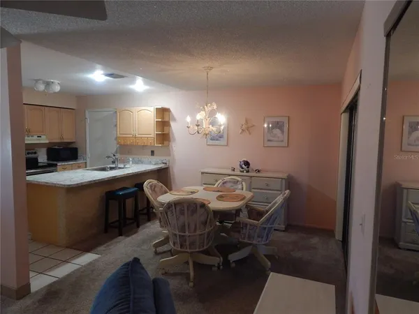 a view of a dining room with furniture and chandelier