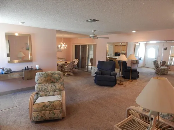 a living room with furniture a large window and gym equipment
