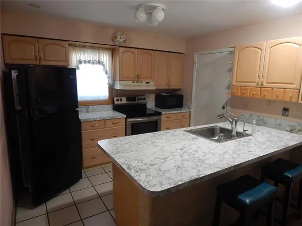 a kitchen with granite countertop kitchen island a refrigerator stove and sink
