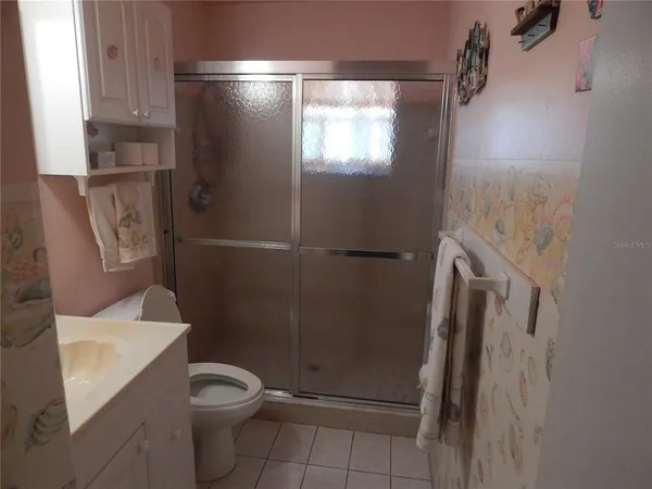 a bathroom with a granite countertop shower and toilet