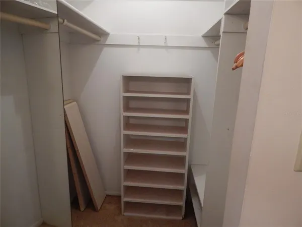 a view of walk in closet with empty racks