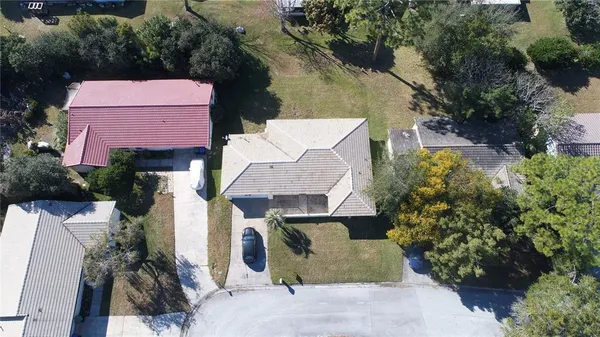 an aerial view of a house with a yard and large tree