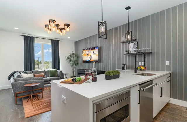 a open kitchen with a sink a counter and chairs