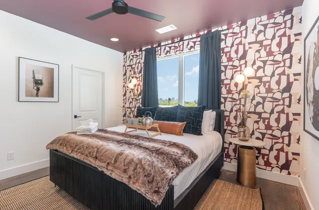 a bedroom with a large bed and a chandelier