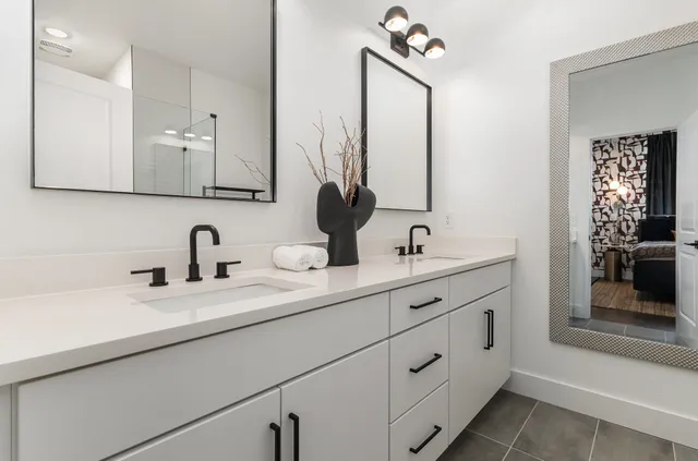 a bathroom with double vanity sink and a mirror