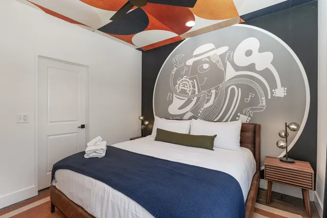 a bedroom with a bed and a painting on the wall