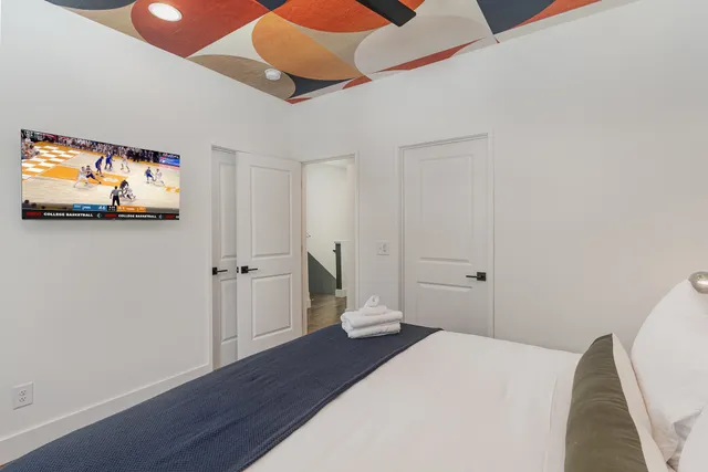 a bedroom with a bed and a flat screen tv