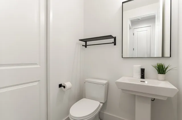 a bathroom with a sink a toilet and mirror