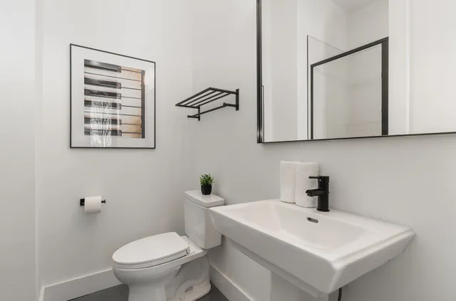 a bathroom with a toilet a sink and mirror