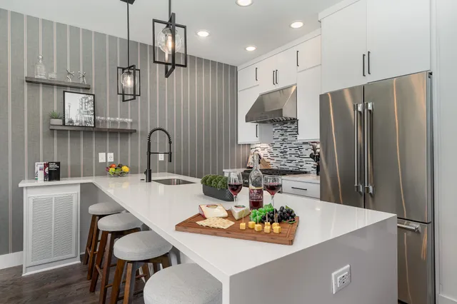 a kitchen with stainless steel appliances granite countertop a sink refrigerator and cabinets