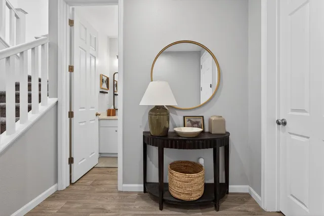 a kitchen with stainless steel appliances granite countertop a stove a sink dishwasher a refrigerator and white cabinets with wooden floor