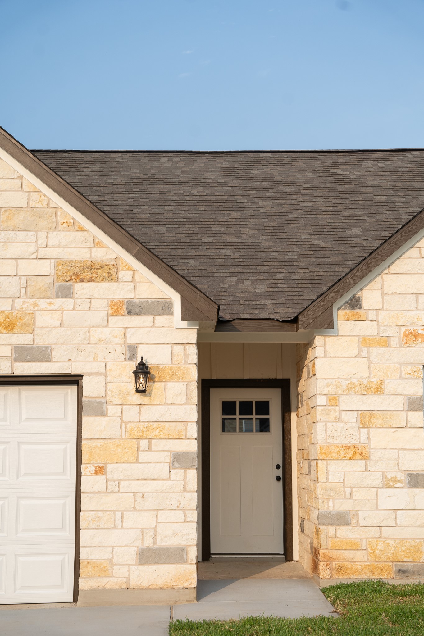 304 String Prairie Way Smithville, TX 78957 - Photo 4 of 30 View of exterior entry with a shingled roof, stone siding, and a garage