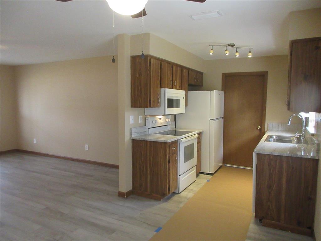 2601 Southeast 175th Terrace Road Silver Springs, FL 34488 - Photo 22 of 87 a kitchen with a refrigerator sink and wooden cabinets