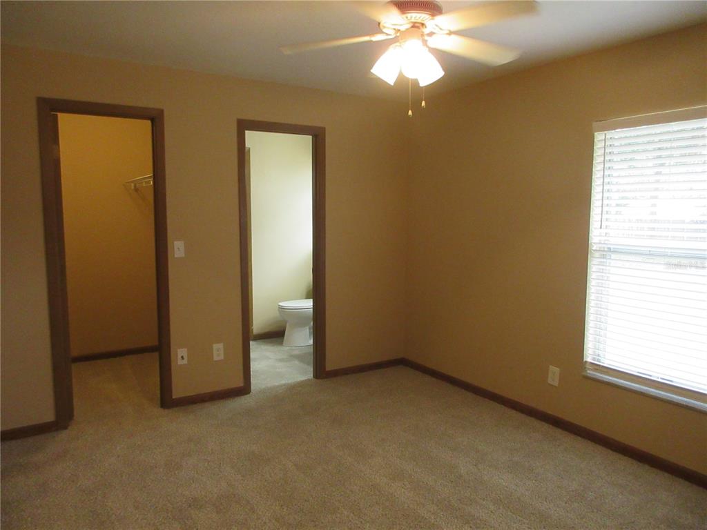 2601 Southeast 175th Terrace Road Silver Springs, FL 34488 - Photo 48 of 87 an empty room with a chandelier fan and a window