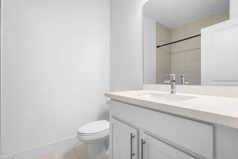 a bathroom with a granite countertop toilet sink and mirror