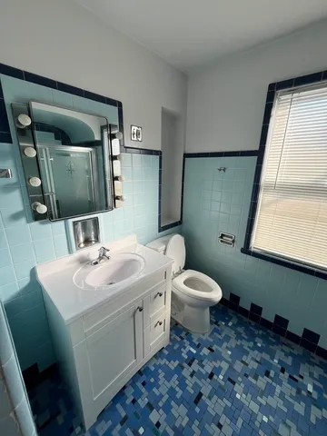 a bathroom with a toilet sink and mirror