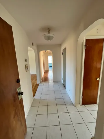 a view of a hallway with wooden floor and cabinet