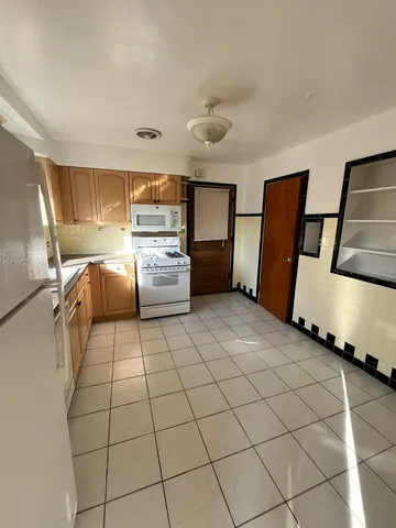 a kitchen with stainless steel appliances cabinets and front door