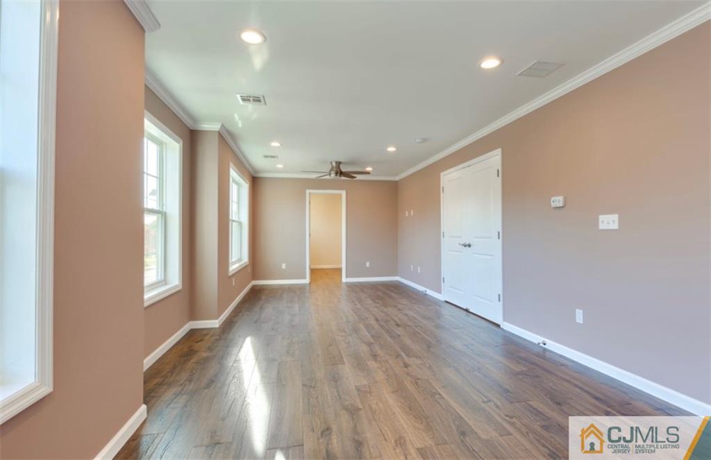 10 Markham Road Edison, NJ 08817 - Photo 13 of 23 a view of an empty room with wooden floor and a window