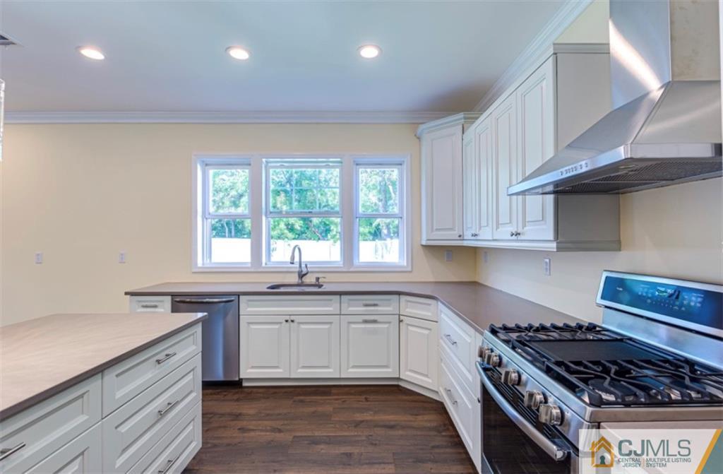 10 Markham Road Edison, NJ 08817 - Photo 4 of 23 a kitchen with stainless steel appliances a sink stove and cabinets