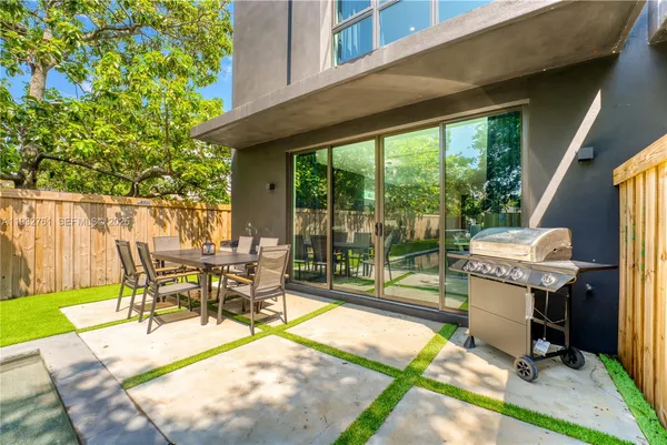 a view of a patio with table and chairs potted plants with wooden floor and fence