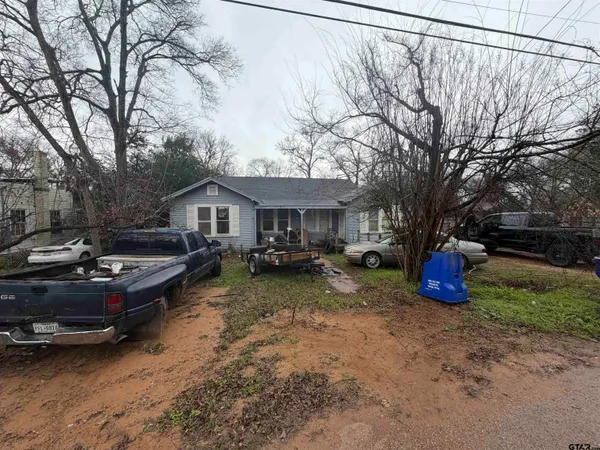 a backyard of a house with barbeque oven and table and chairs