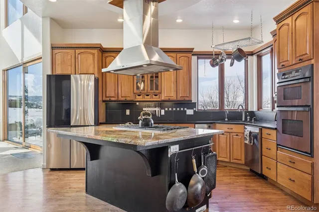 a kitchen with stainless steel appliances granite countertop a sink a stove and a refrigerator