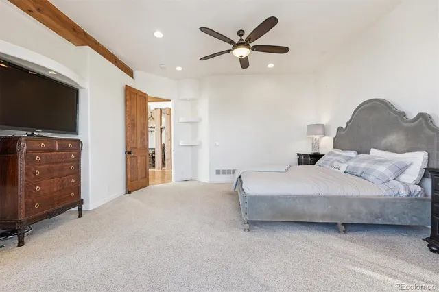 a spacious bedroom with a bed and a flat screen tv