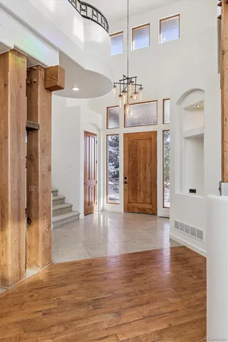 a view of a hallway with wooden floor and chandelier