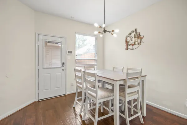 a view of a dining room with furniture a chandelier and wooden floor