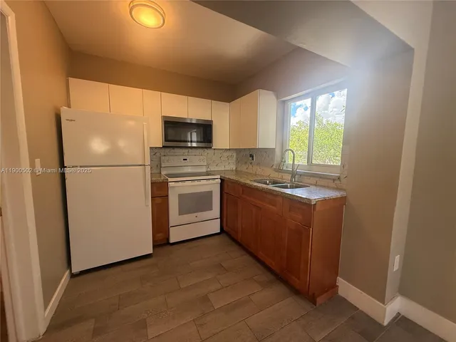 a kitchen with stainless steel appliances granite countertop a refrigerator a stove a sink dishwasher and a refrigerator