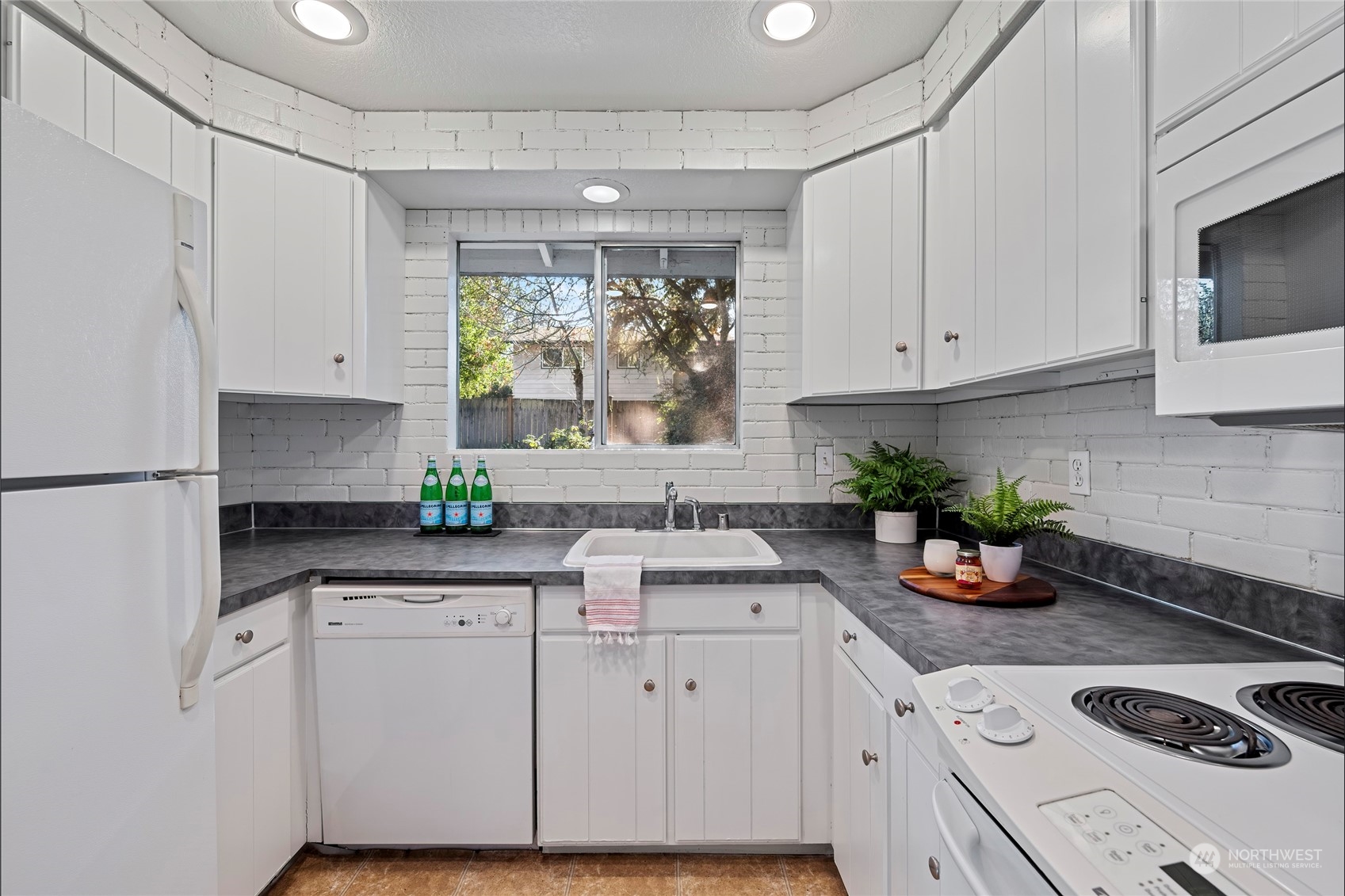704 221st Street Southwest Bothell, WA 98021 - Photo 9 of 21 a kitchen with white cabinets and a window