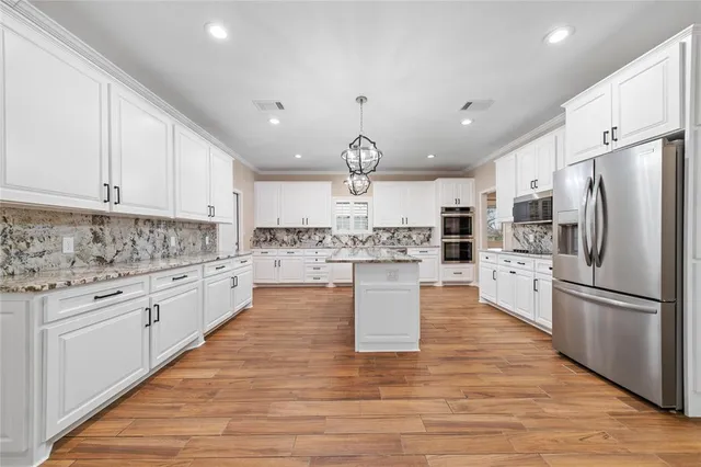 a kitchen with a stove cabinets and wooden floor