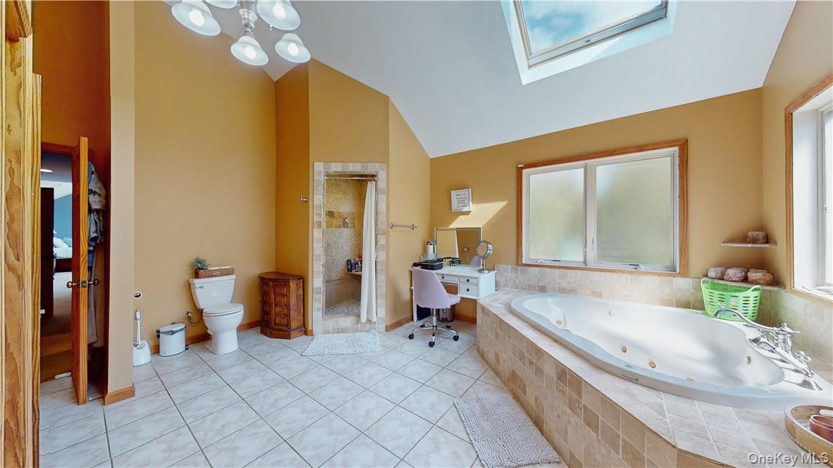 75 Monahan Road Port Jervis, NY 12771 - Photo 28 of 36 Bathroom with tile patterned flooring, separate shower and tub, toilet, and vaulted ceiling with skylight