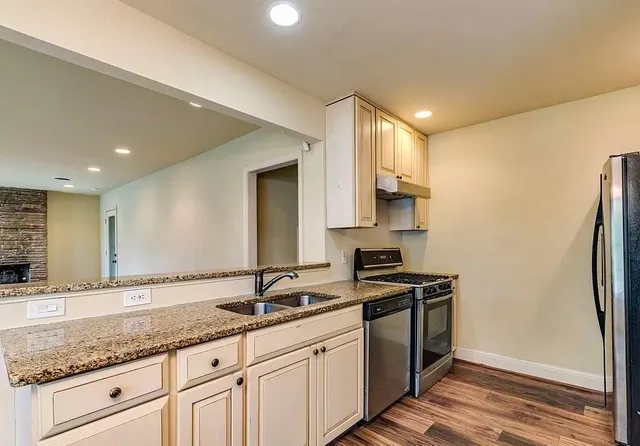 a kitchen with granite countertop a refrigerator and a sink