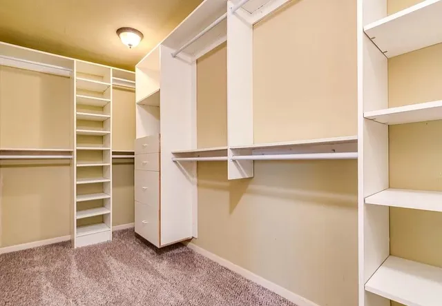 a view of walk in closet with empty racks