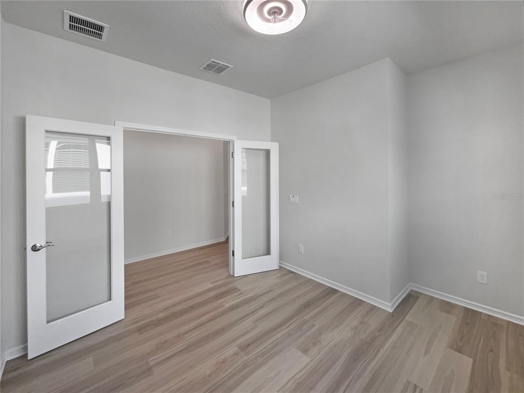 1909 Spring Shower Circle Kissimmee, FL 34744 - Photo 15 of 32 an empty room with wooden floor and windows