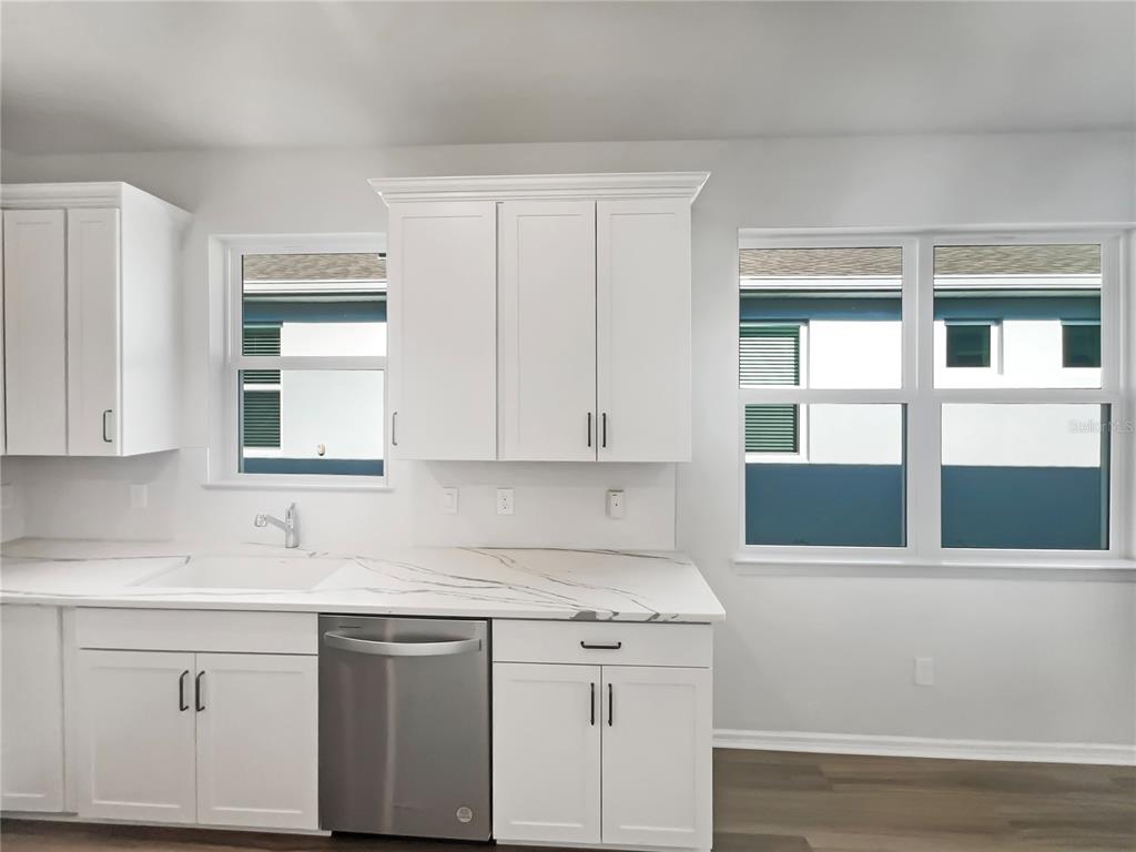 1909 Spring Shower Circle Kissimmee, FL 34744 - Photo 22 of 32 a kitchen with stainless steel appliances granite countertop white cabinets and window