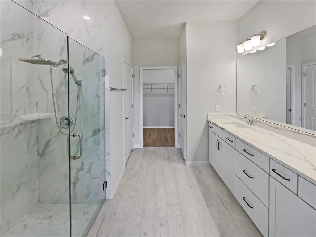 1909 Spring Shower Circle Kissimmee, FL 34744 - Photo 26 of 32 a spacious bathroom with a granite countertop sink a shower and a mirror