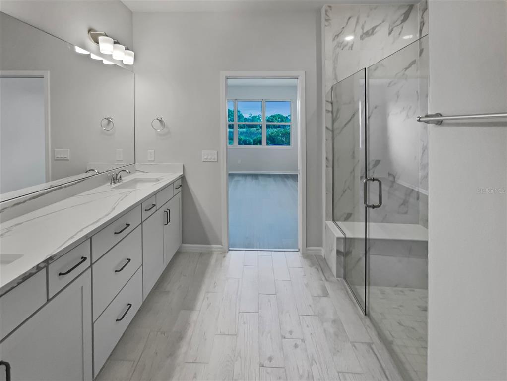 1909 Spring Shower Circle Kissimmee, FL 34744 - Photo 29 of 32 a bathroom with a double vanity sink a large mirror and shower