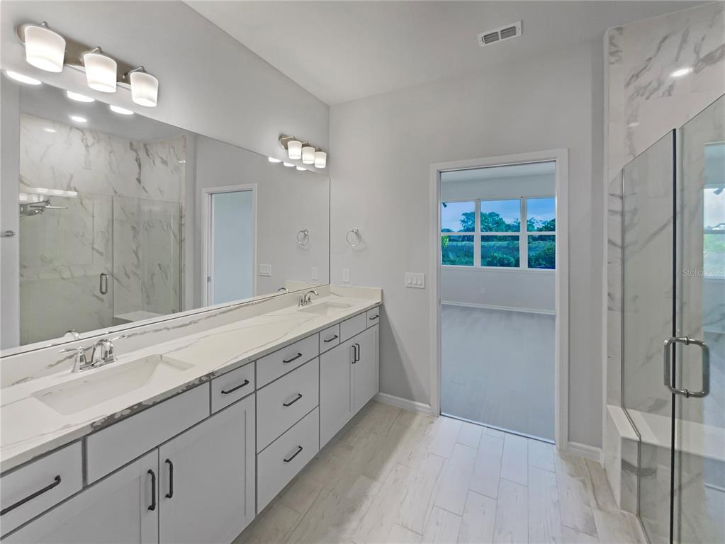 1909 Spring Shower Circle Kissimmee, FL 34744 - Photo 30 of 32 a spacious bathroom with a double vanity sink a large mirror and a shower