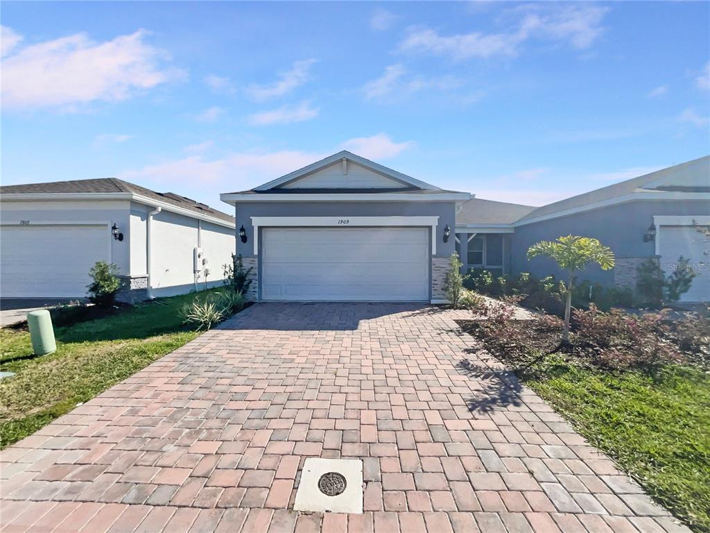 1909 Spring Shower Circle Kissimmee, FL 34744 - Photo 7 of 32 a front view of a house with a yard and garage