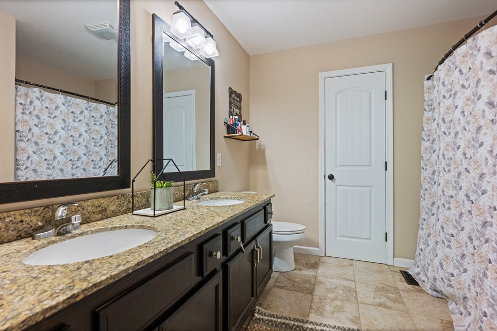 5006 Jimmie Neal Road Baxter, TN 38544 - Photo 13 of 22 a bathroom with a granite countertop sink and a mirror
